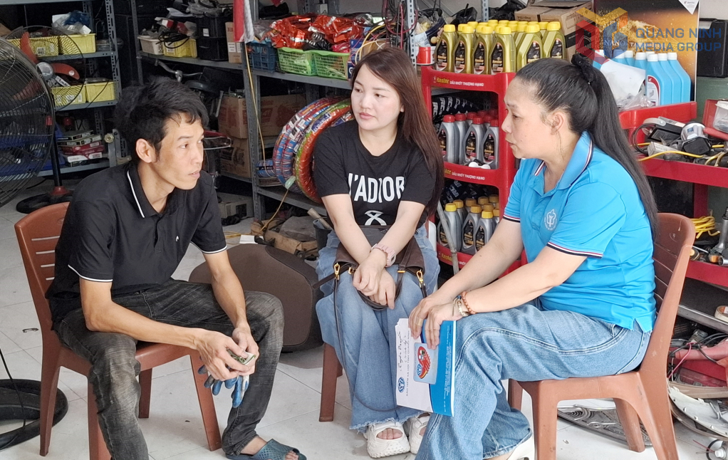 Cán bộ BHXH tỉnh tư vấn hướng dẫn cho anh Nguyễn Văn Vương chủ hộ sửa chữa xe máy ở phường Cao Xanh (TP Hạ Long) làm hồ sơ đăng ký tham gia BHXH bắt buộc.