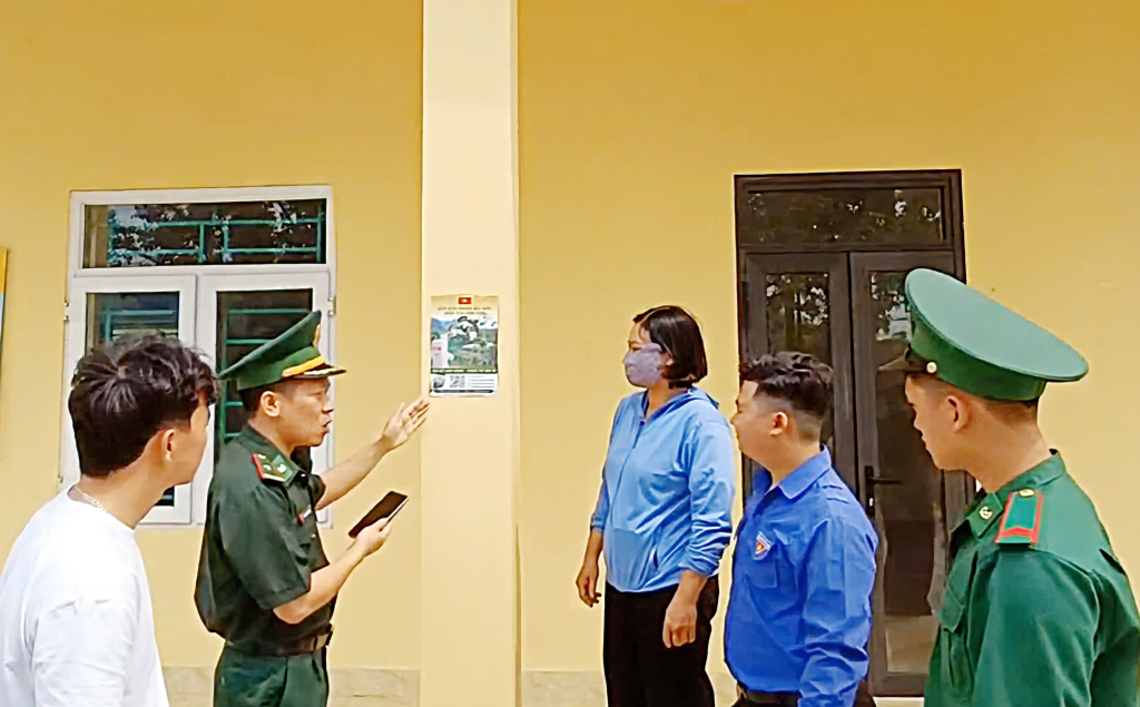 Cán bộ Đồn BP Bắc Sơn hướng dẫn người dân thôn Lục Phủ, xã Hải Sơn cách quét mã QR để tố giác tội phạm.