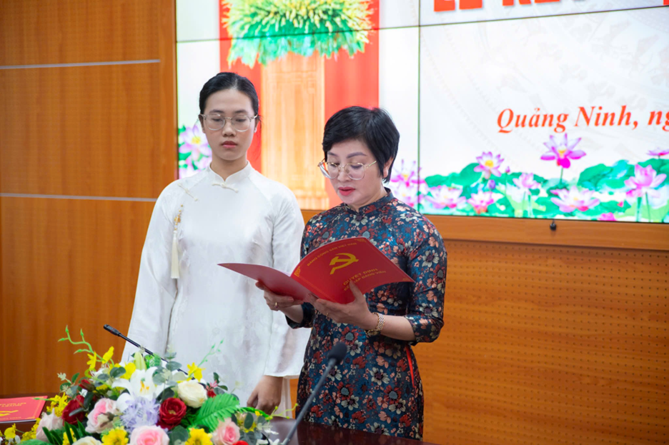 A person standing next to a person holding a red bookAI-generated content may be incorrect.