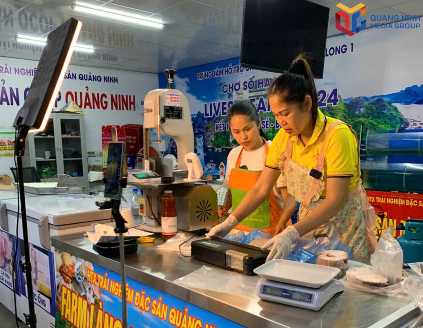 Chị Nguyễn Thúy Hà, Giám đốc HTX Nông - Lâm - Ngư nghiệp Việt Hưng, phường Hoành Bồ (bên trái) livestream bán hàng tại gian hàng chuyển đổi số, chợ Hạ Long 1 (phường Hồng Gai). bqn_tr_c-ha.jpg
